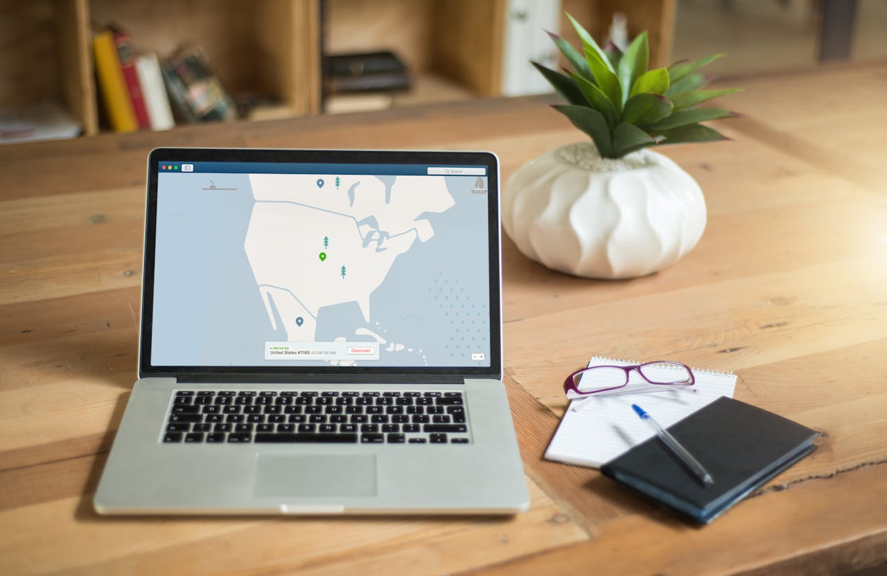 Laptop with a map and a notepad on a table